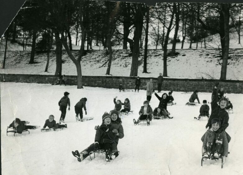 A group of children sledging on the snow at Lochee Park in December 1973. Image: DC Thomson.