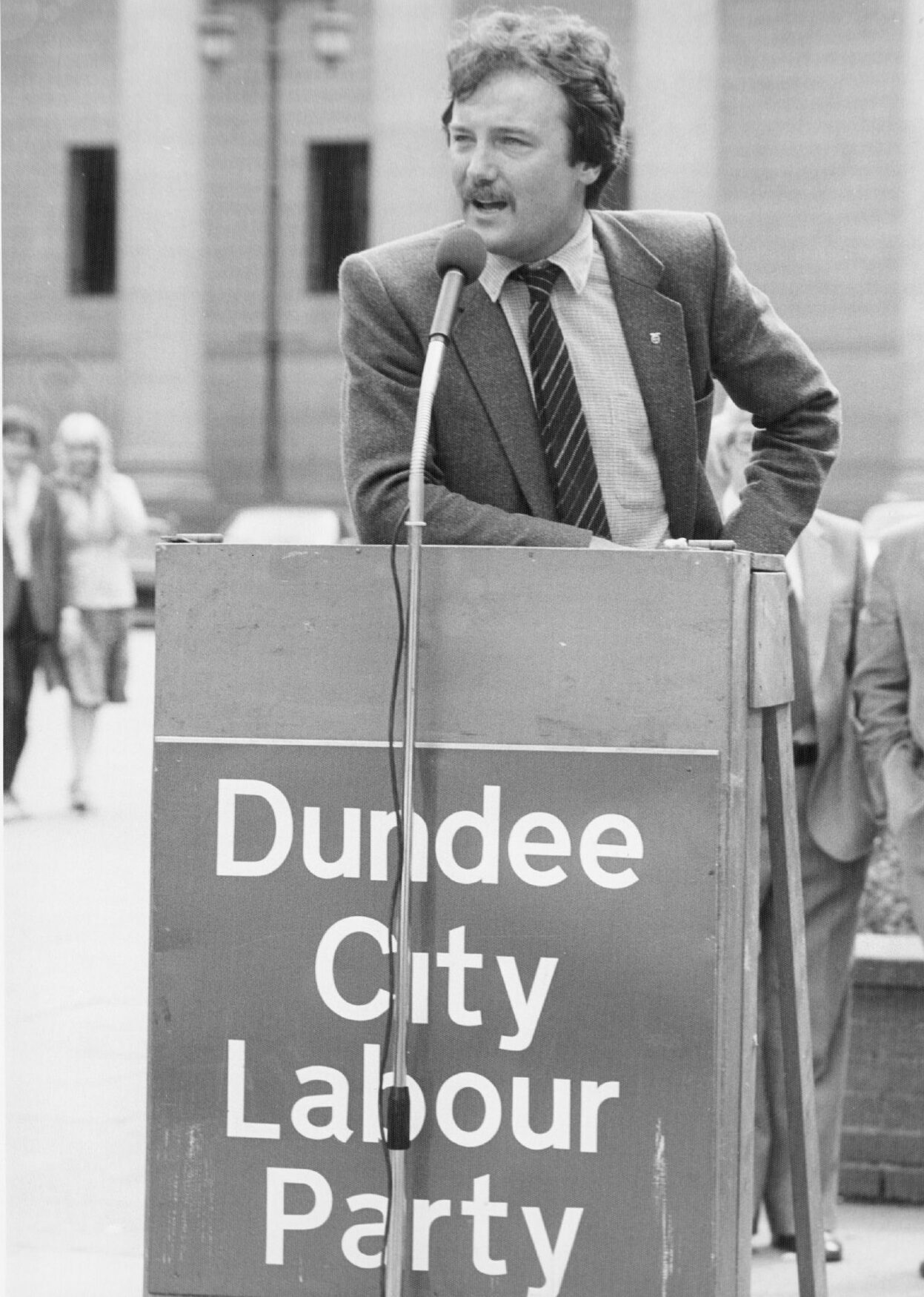 George Galloway stands at a Dundee City Labour Party podium in City Square