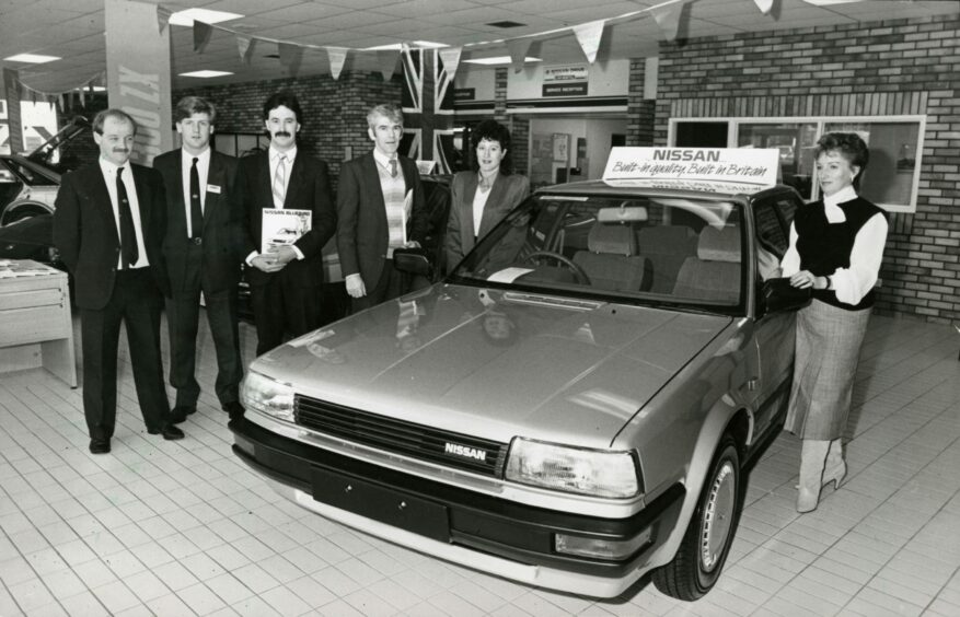 Martin Motors staff standing beside a Nissan in 1986. Image: DC Thomson.