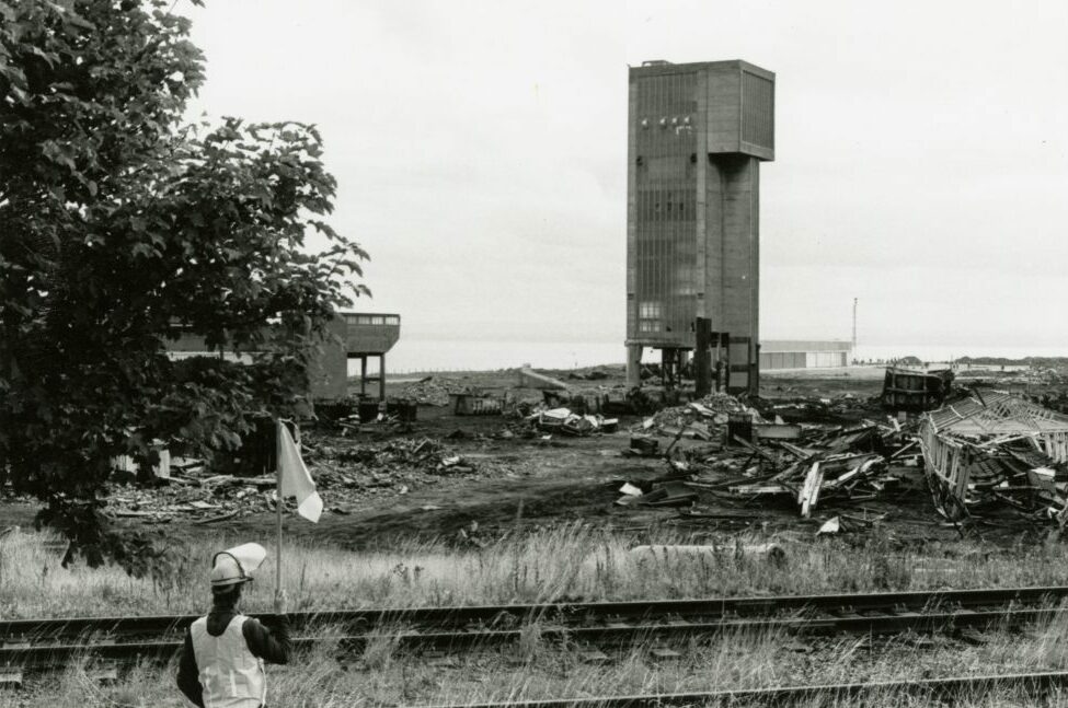 A worker in the foreground looks on as the Seafield Colliery demolition work starts.