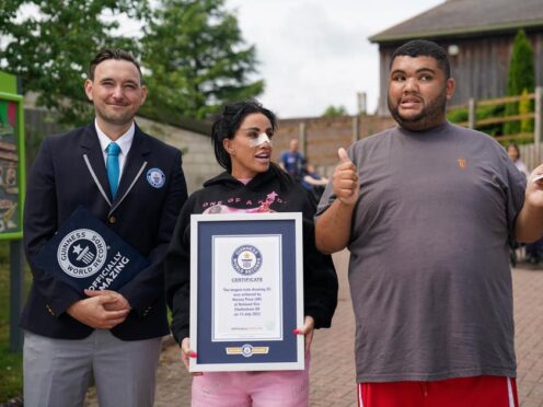 Guinness World Record adjudicator Will Munford, Katie Price and her son Harvey as he is presented with the Guinness World Record for the longest drawing of a train (Jacob King/PA)