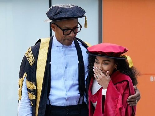 Chancellor of Buckinghamshire New University Jay Blades watches Leigh-Anne Pinnock react to a group of student performing a flash mob at Buckinghamshire New University (Andrew Matthews/PA)