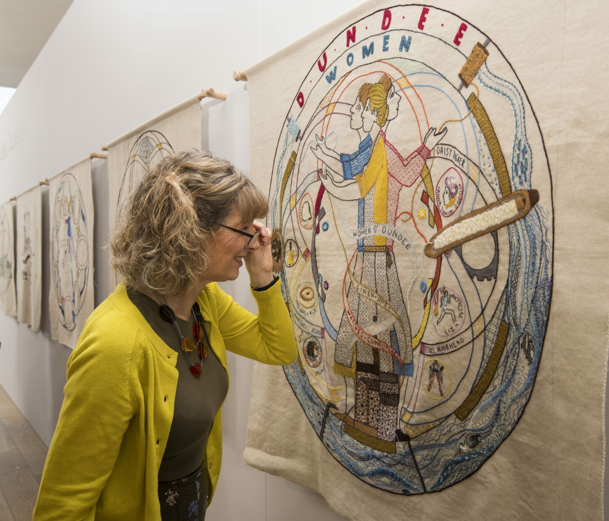 Lindsey Grieve inspects one of the tapestry panels at the V&amp;A in Dundee.
