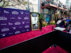 Guests are guided away from an empty red carpet at the world premiere of Disney’s Haunted Mansion at Disneyland, in Anaheim, Calif. Actors and screenwriters did not walk the red carpet due to picketing that has shut down production across the entertainment industry (AP Photo/Ashley Landis)