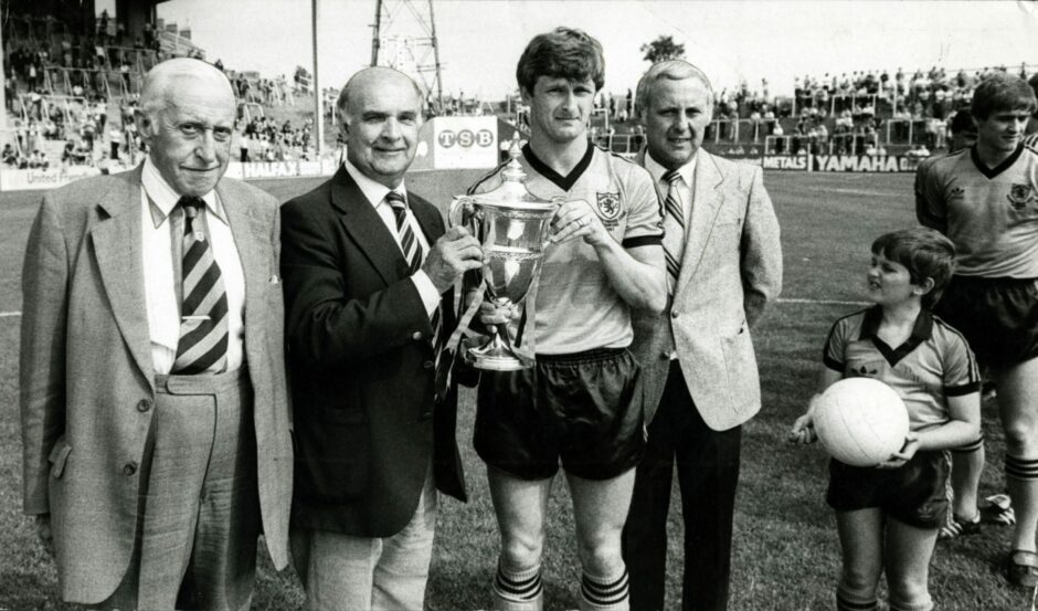 Scottish League chairman David Letham holds the championship trophy with Dundee Untied captain Paul Hegarty.