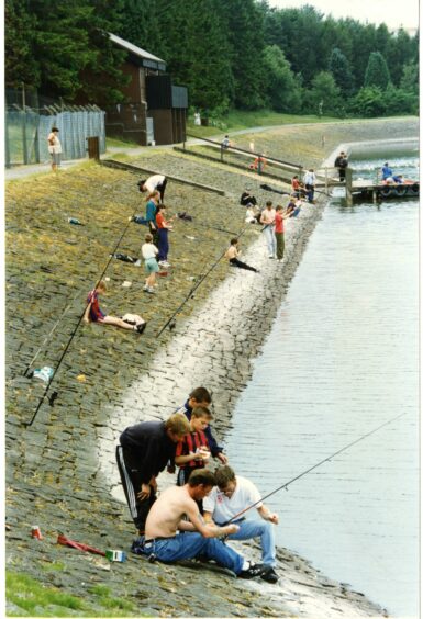 A crowd of people fishing AT Clatto Country Park in 1996. 