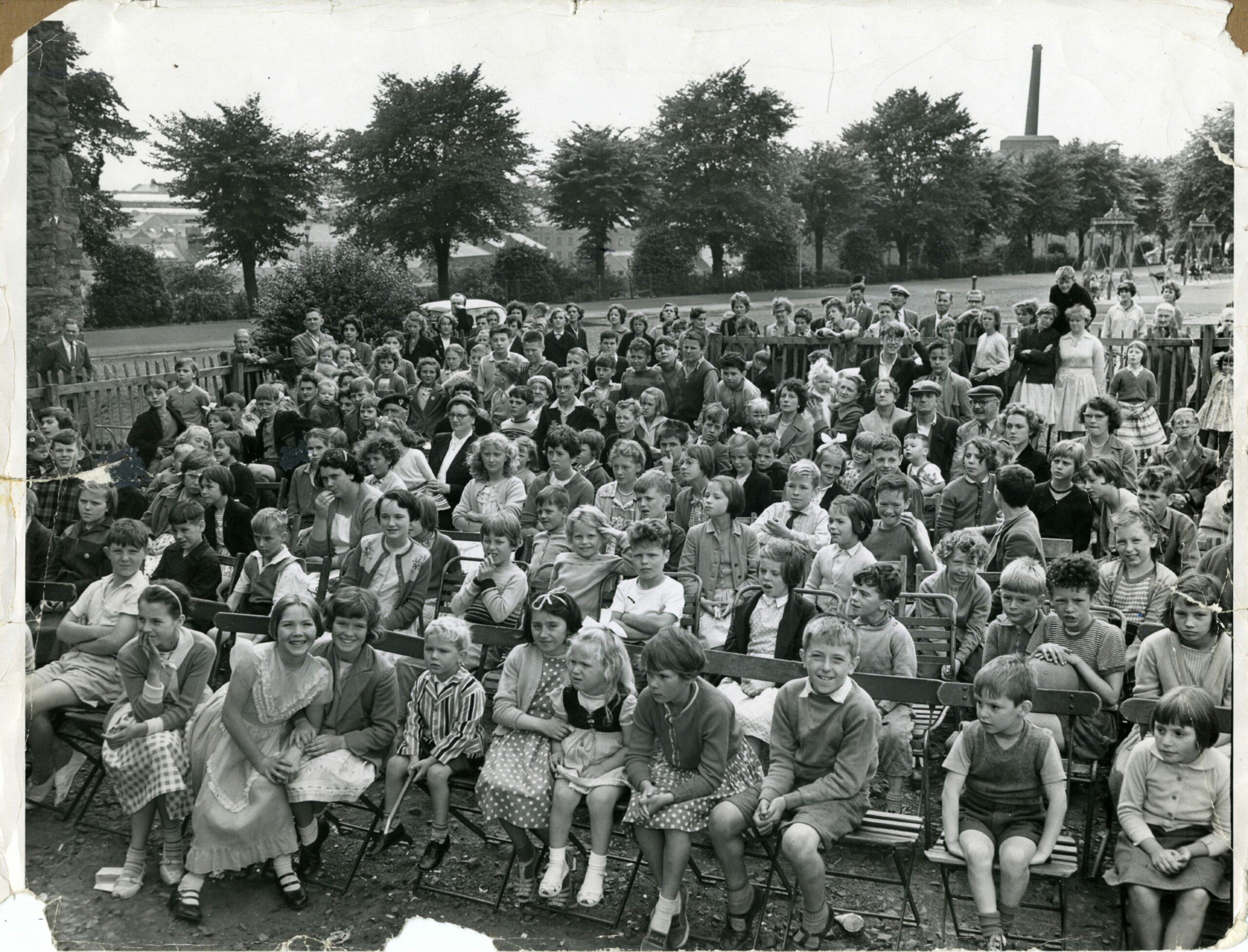 A crowd of children sitting down at an event in Dudhope Park in 1960