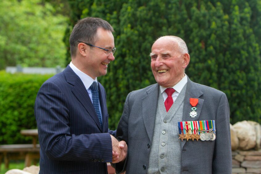 Willian (Bill) Tavendale receives his award, the Legion d'honneur, from Emmanuel Cocher France's Consul General in Scotland.