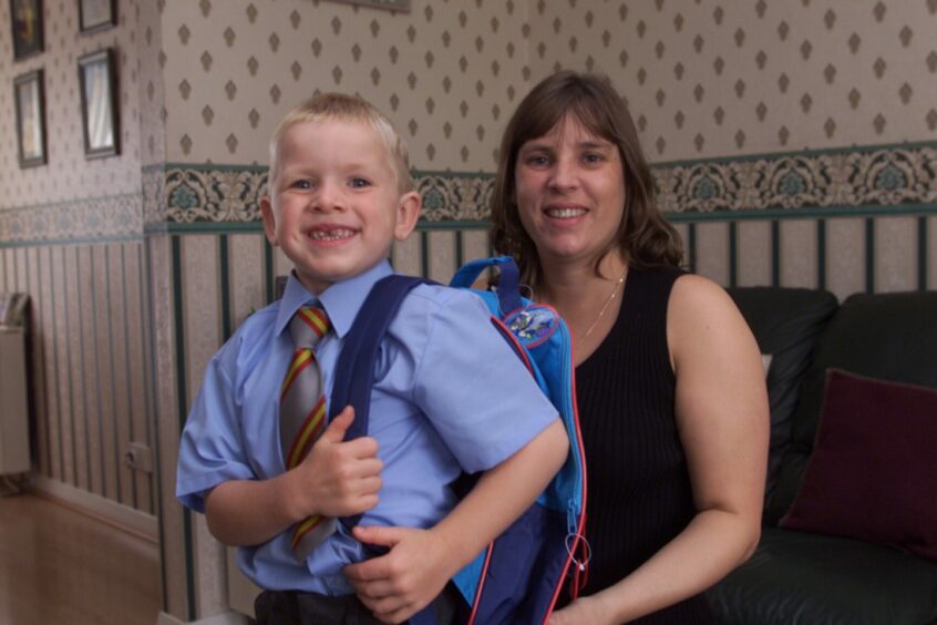 Josh Moncrieff is helped on with his schoolbag by his mum, Gillian Moncrieff. Image: DC Thomson.