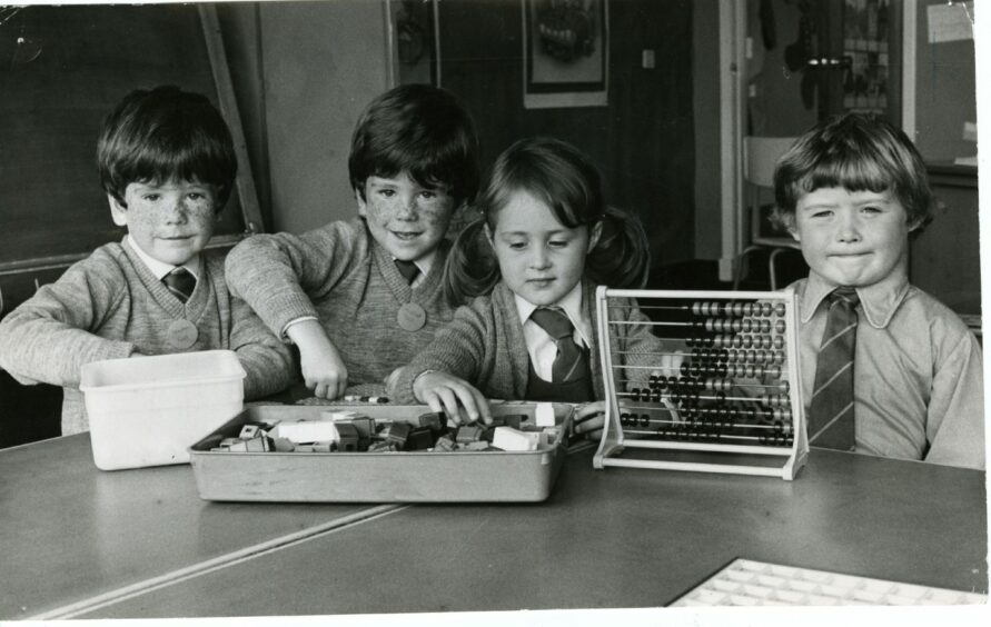 Stephen and Michael Gall and Alison and Craig Dick at a school desk. Image: DC Thomson.