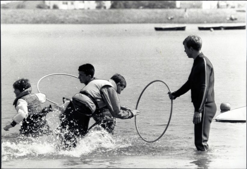 Children playing in the water with hula hoops during the competition