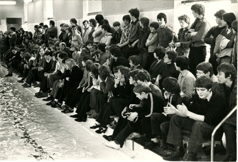 Spectators cram the sides of the Menzieshill High School pool in February 1980 as the 20-strong swimming team regain the world record for the 100-mile relay.