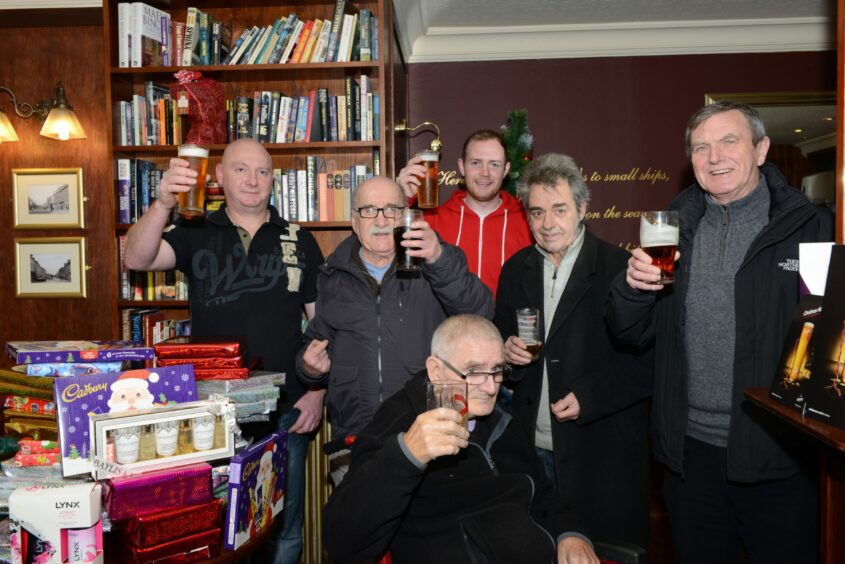 These regulars raise a glass following a charity venture at the pub in 2014.  Image: Supplied.