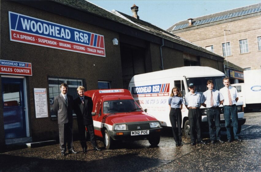 Image shows the exterior of the shop with branded vans and staff members. Image: DC Thomson.