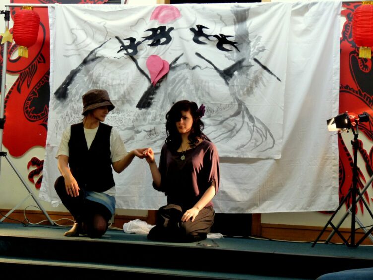 Two girls on a stage in a performance in the Hilltown to celebrate Chinese Valentine's Day. Image: Front Lounge.