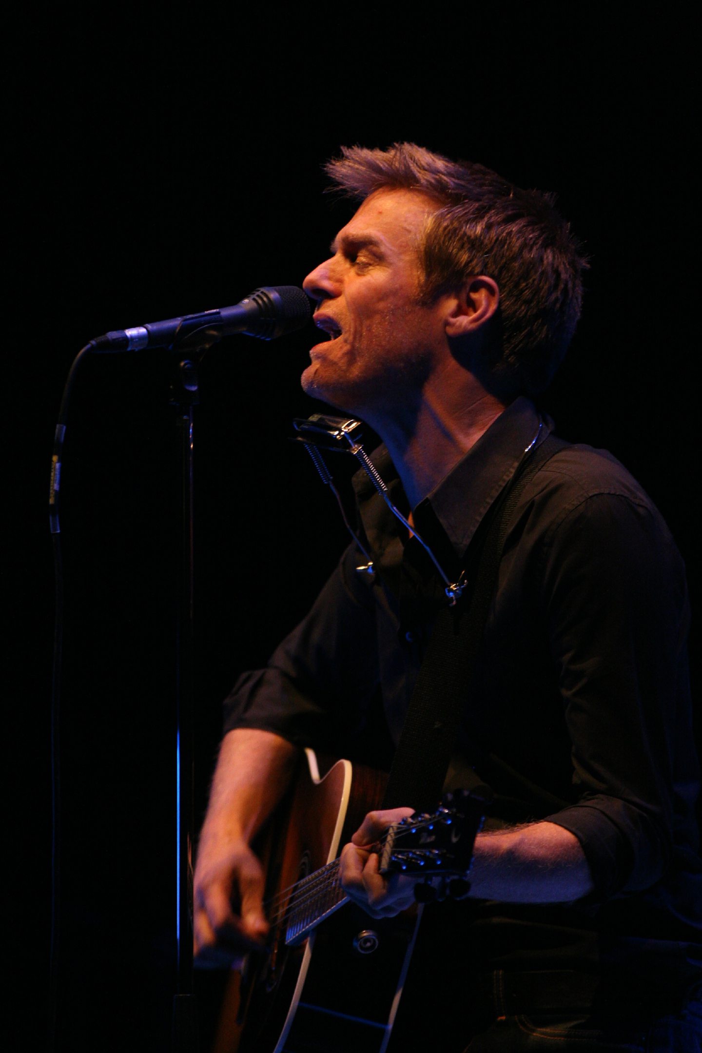 Bryan Sings into the microphone during his solo show at The Caird Hall in Dundee.