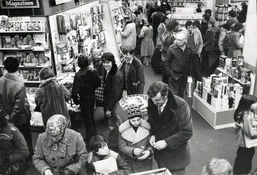 Elevated view of shoppers browsing the goods on sale in John Menzies in 1978.