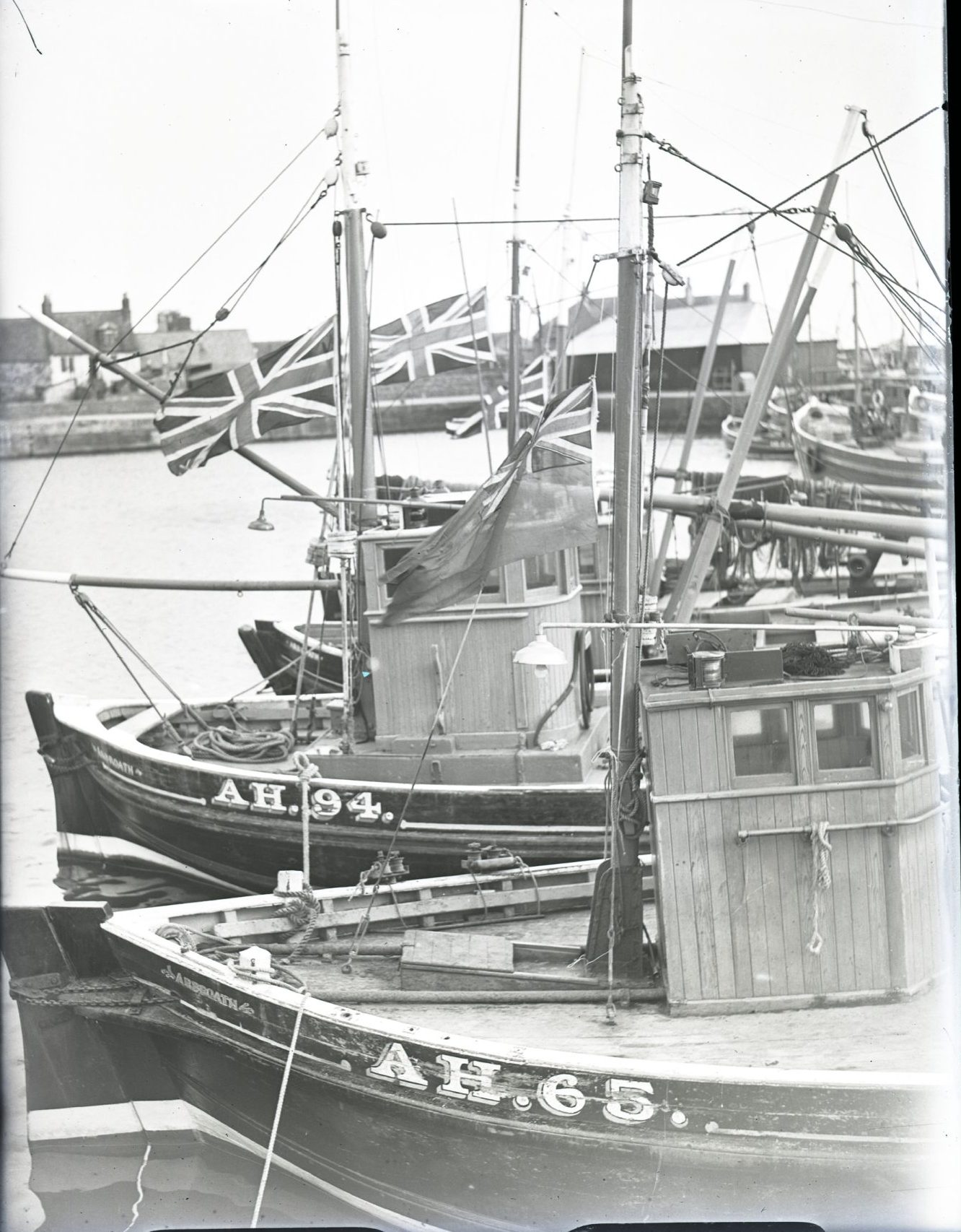 The boats in Arbroath harbour fly their flags at half mast to mark the funeral of the crew. Image: DC Thomson.