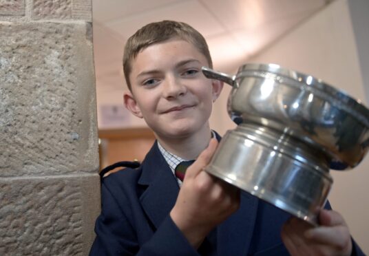 13-year-old piper Callan Erskine of Bertha Park pictured with the DR DS MacLaggan Memorial Trophy, which he won at the Royal National Mod in Paisley.