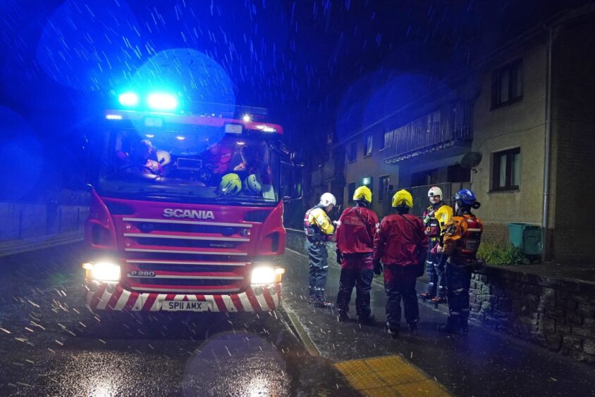 Emergency services in River Street in Brechin knock on doors and ask residents to evacuate due to flood warnings. Image: PA.