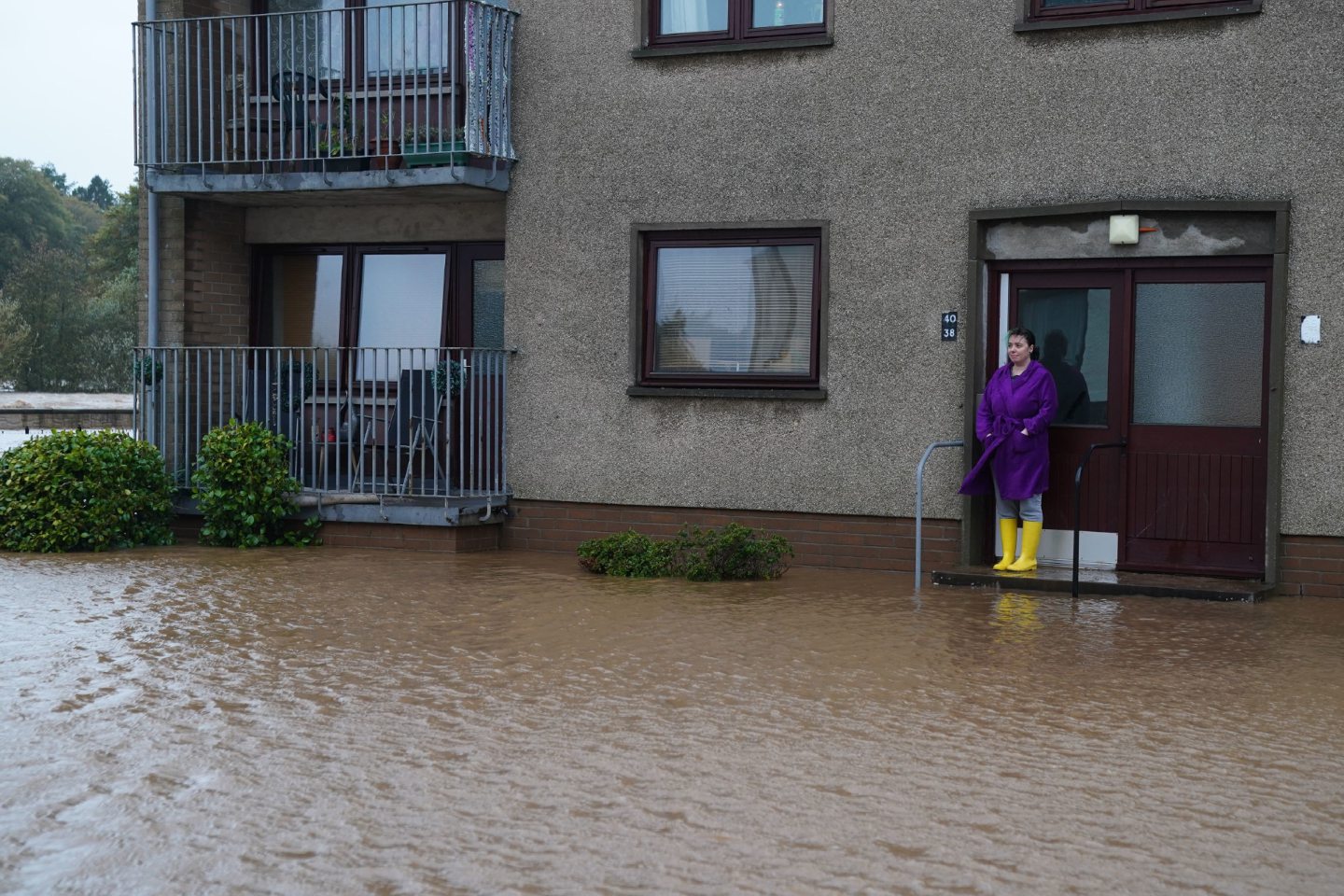 Rosie Galloway, wearing her yellow wellies, looks out to the flood water outside her Brechin home.