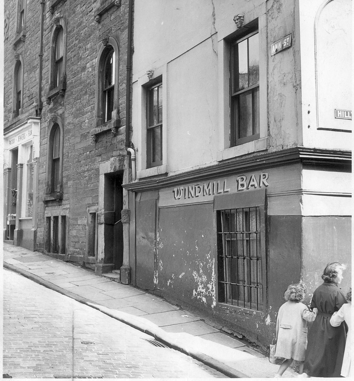 The carved masks can be seen on the side of the Windmill Bar in 1960. Image: DC Thomson.