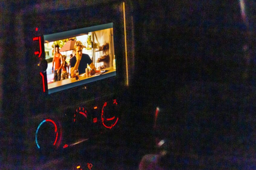 Walker playing in a movie being shown in one of the cars