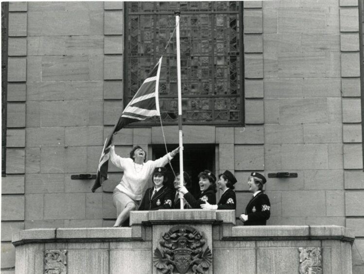 Members of the 20th Menzieshill Girls' Brigade raising a flag on the tiny balcony at Dundee City Chambers in October 1987.