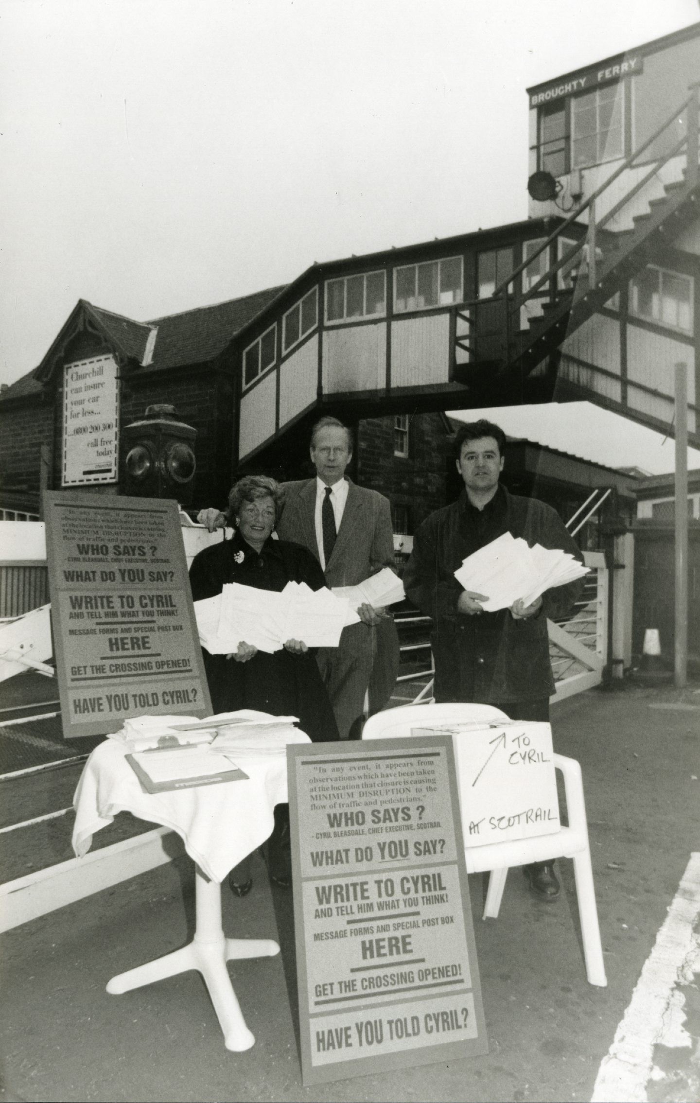 Members of the public hold leaflets and signs at the level crossing protest. Image: DC Thomson.