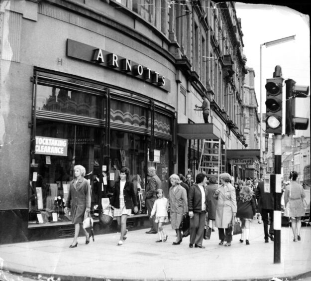 Workmen changing the name on D.M. Brown to Arnotts in Dundee in 1972. Image: DC Thomson.