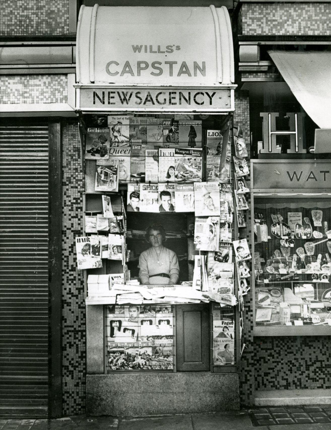 A woman looks out from a newsagent on High Street in 1975. Image: DC Thomson.