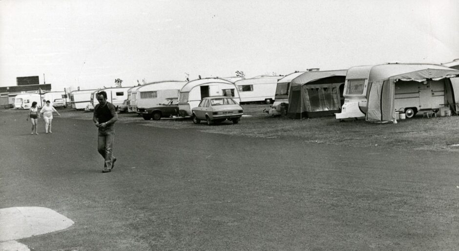 Rows of caravans and individuals walking on the road next to them. Image: DC Thomson.