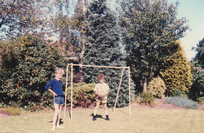 Neil plays goalkeeper in the back garden during a game with brother Alan. Image: Supplied.