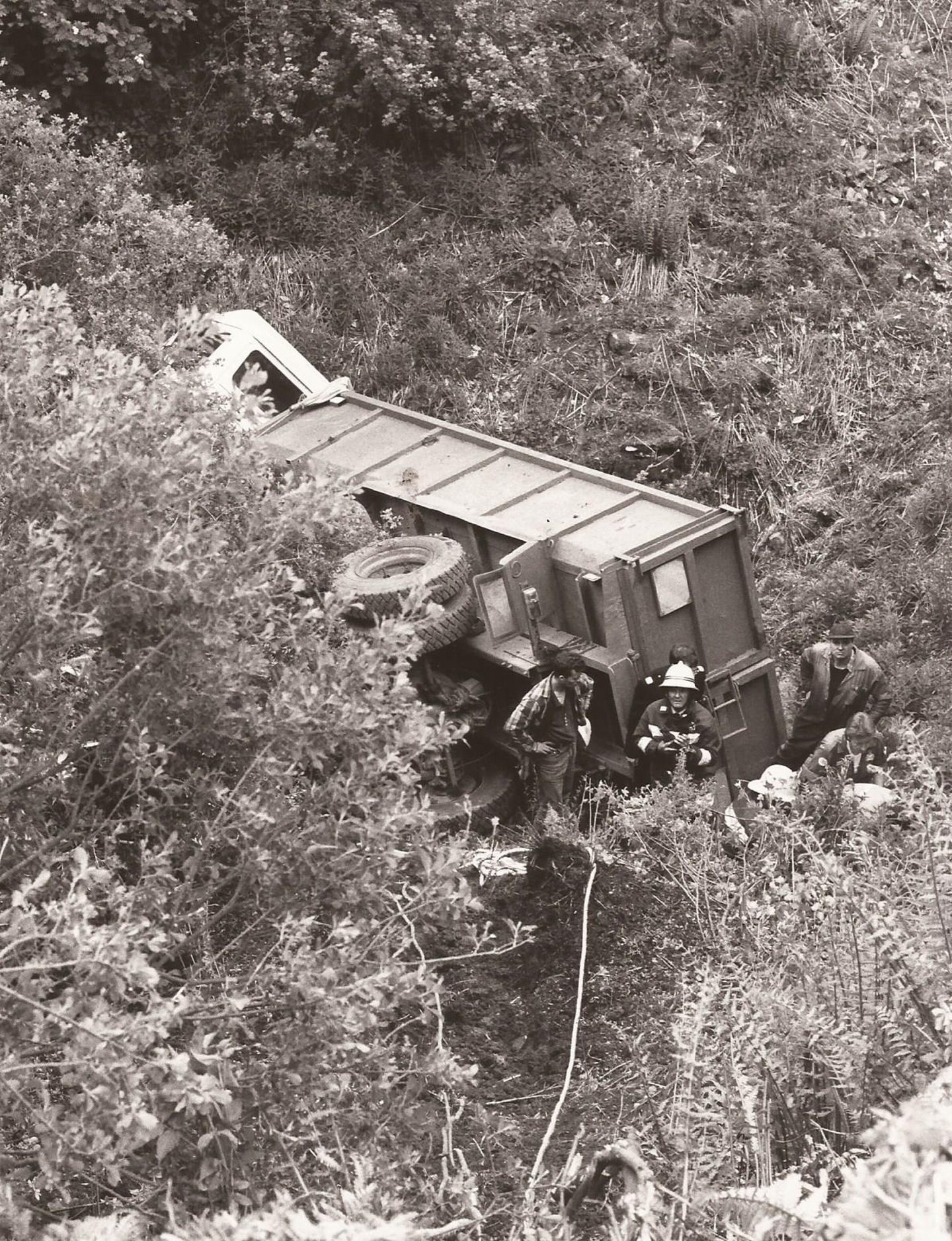 The lorry on its side at the foot of the embankment.