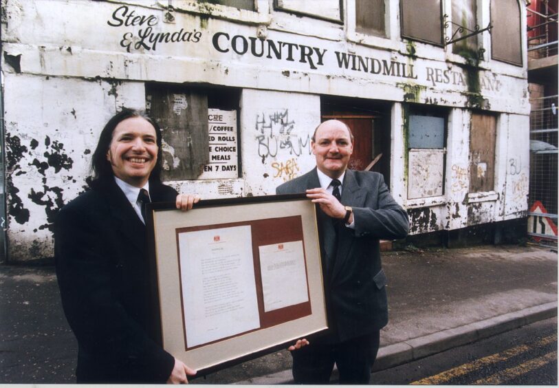 Iain Mitchell and David McKenzie bring out the duke's framed ode in February 1999. Image: DC Thomson.