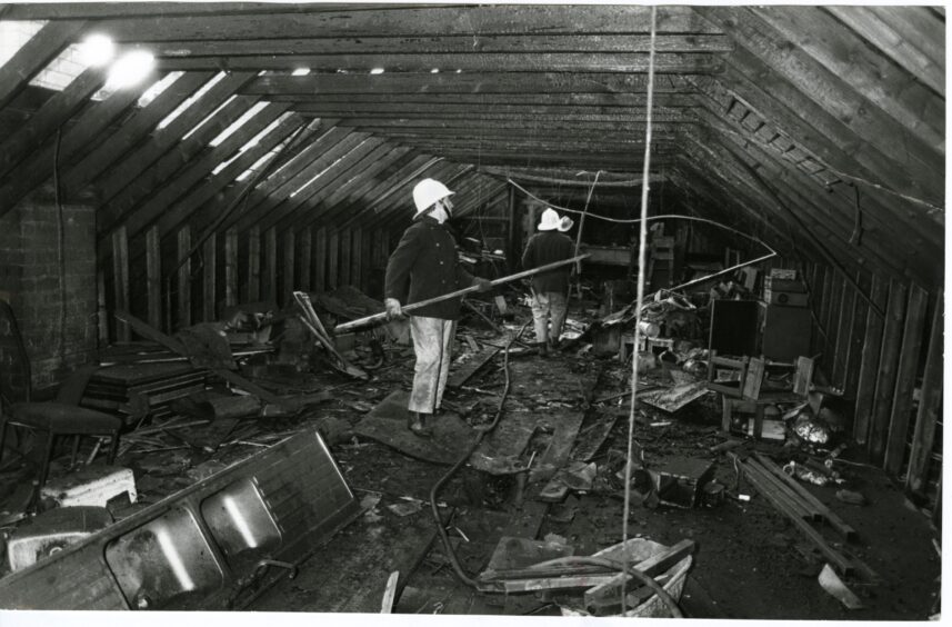 Firefighters inside the gutted roofspace following The Fountain nightclub fire in 1985.