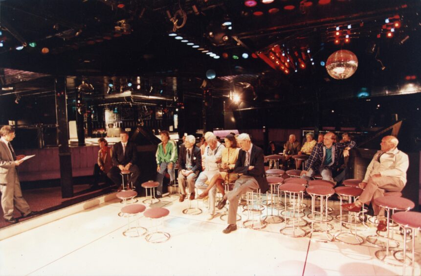 Image shows a small crowd sitting on stools on the dancefloor. Image: DC Thomson.