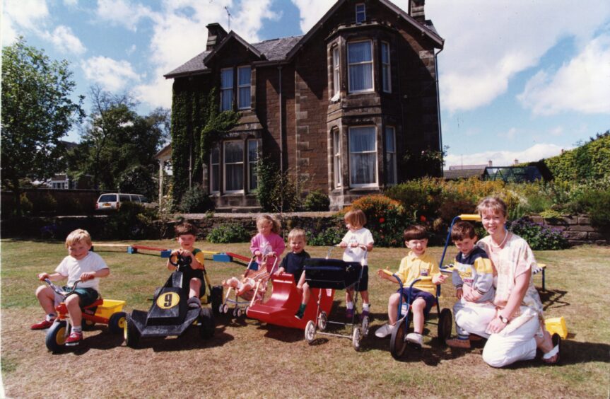 Ruth Orr with the children on the nursery lawn. Image: DC Thomson.