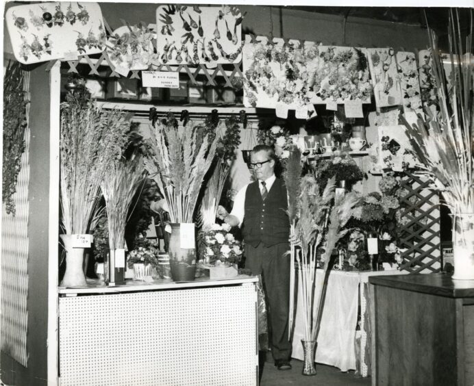 Mr JR Ritchie photographed at his RVR Floral stall at the Dens Road Market in 1972. Image: DC Thomson.