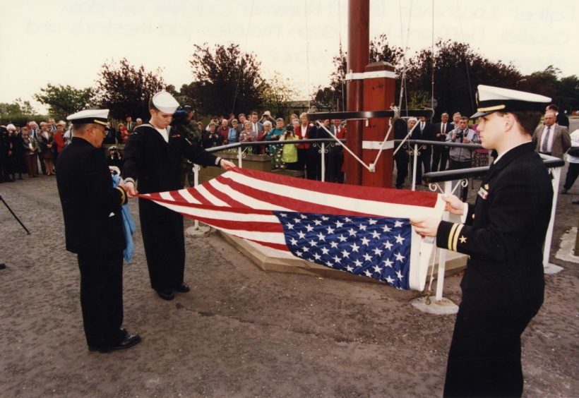 The stars and stripes are folded by military personnel as the base closes in 1997. 
