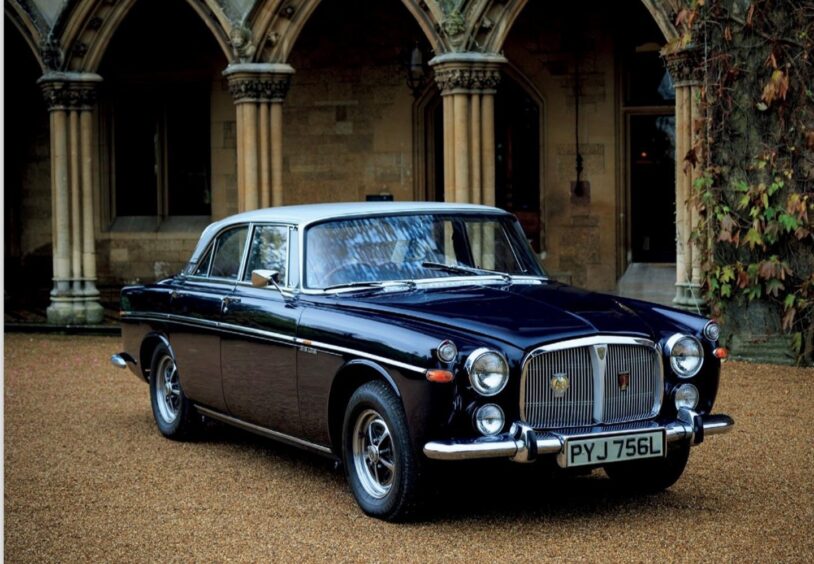 The Rover P5B on a gravel driveway outside a grand building with columns