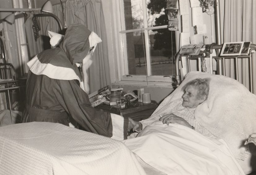 Santa sits by the bedside of Janet B. Lowe in 1981.