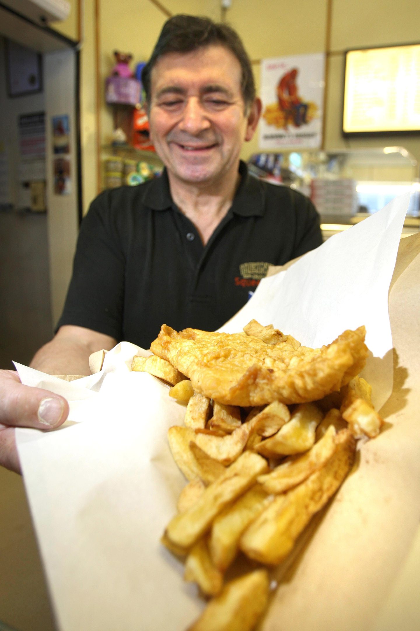 A smiling Giulio with another just-cooked fish supper at Dora's