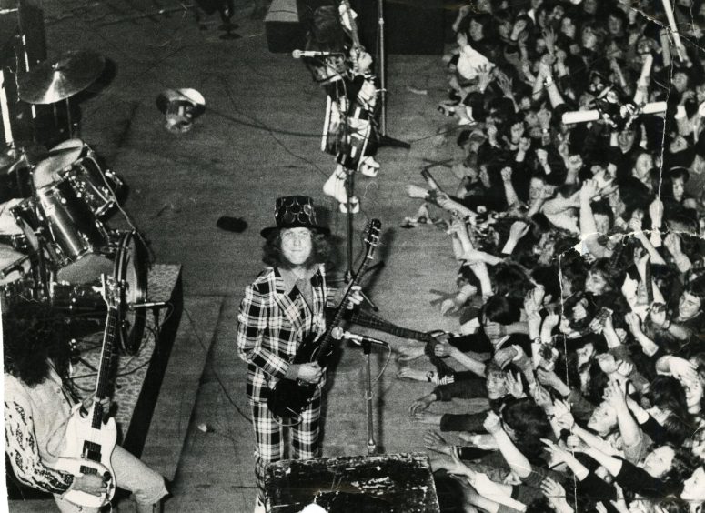 Fans crowd the front of the stage as Slade and frontman Noddy Holder perform in May 1974. 
