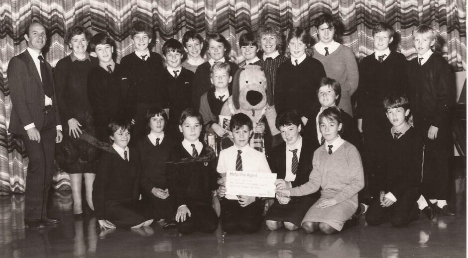 Pupils and staff on stage for the cheque presentation in 1986.