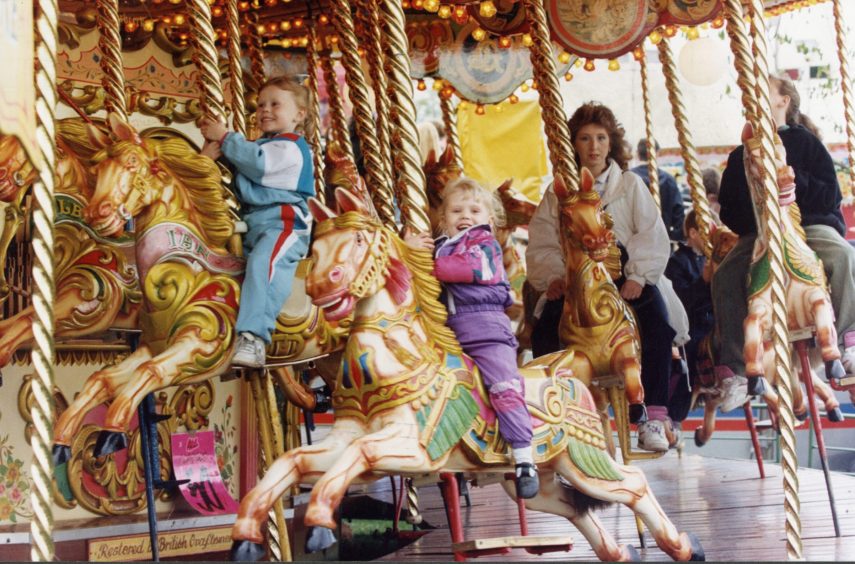 Children and parents ride the carousel