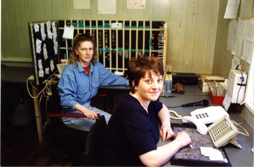 Two staff members seated in the Handy Taxis control room.