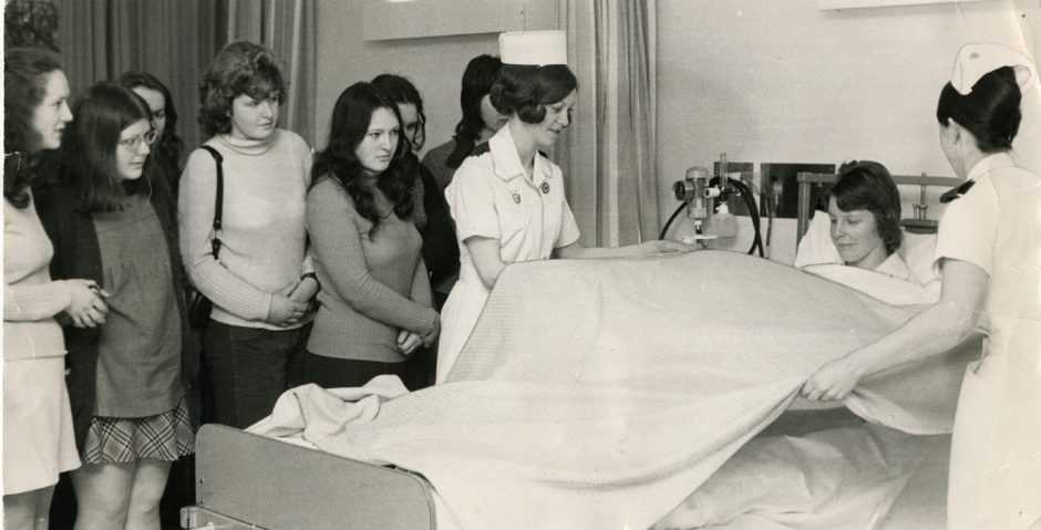 Nurses tend to a patient while looking on are other nurses who are being given instruction in good bedside manner at Ninewells Hospital. 