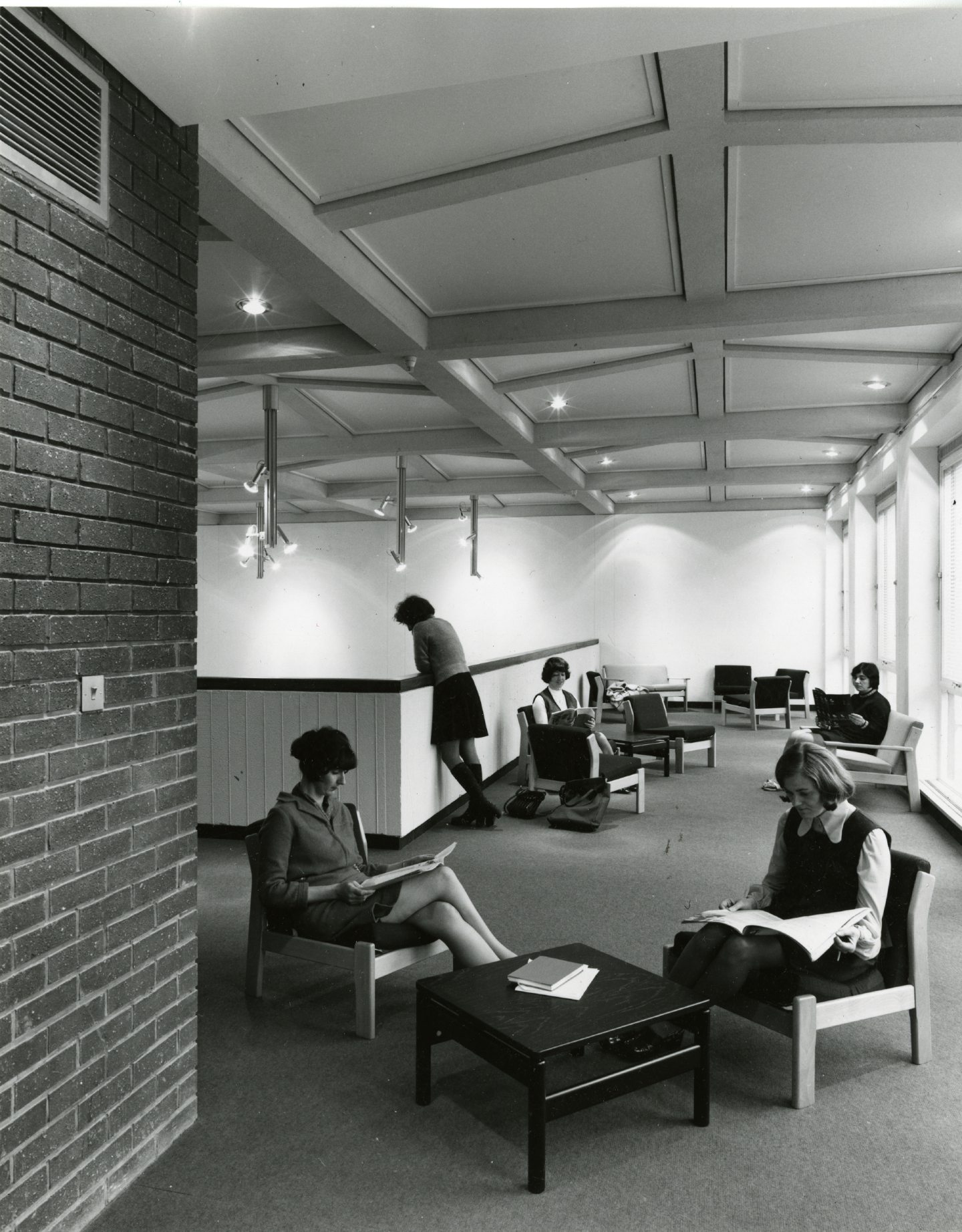 Female students can be seen seated reading textbooks in the common room gallery area.