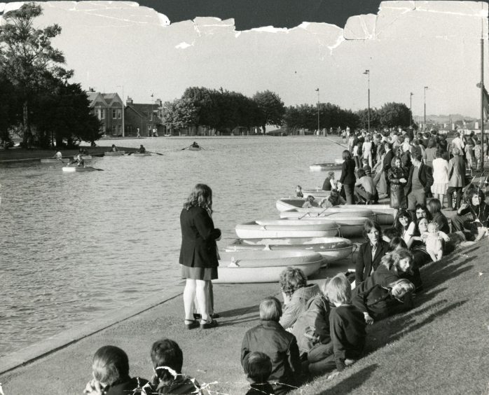 The crowd seated beside the water for the sponsored row.